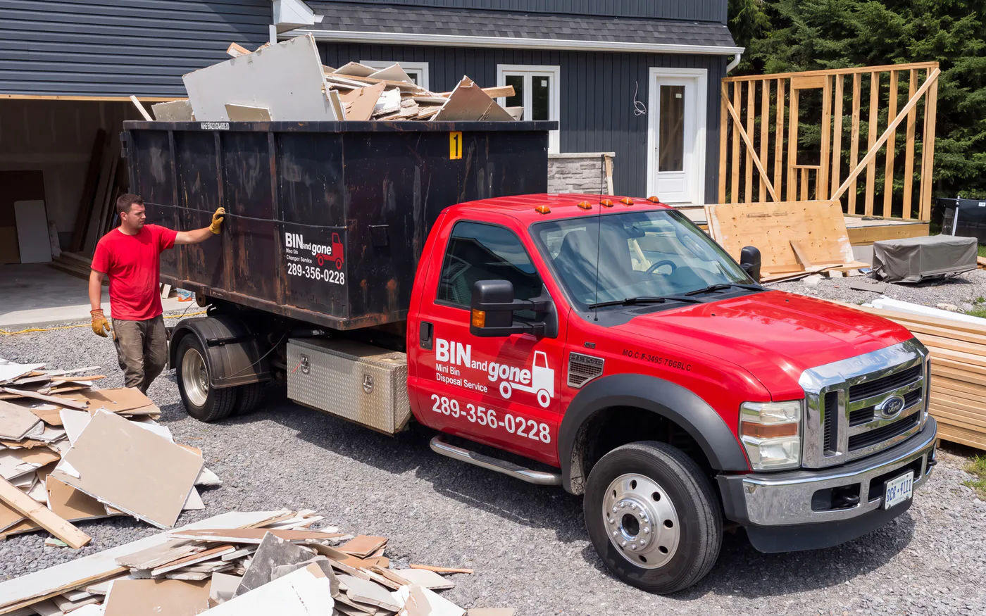 Illustration of a person beside a red truck carrying a black bin filled with renovation debris.
